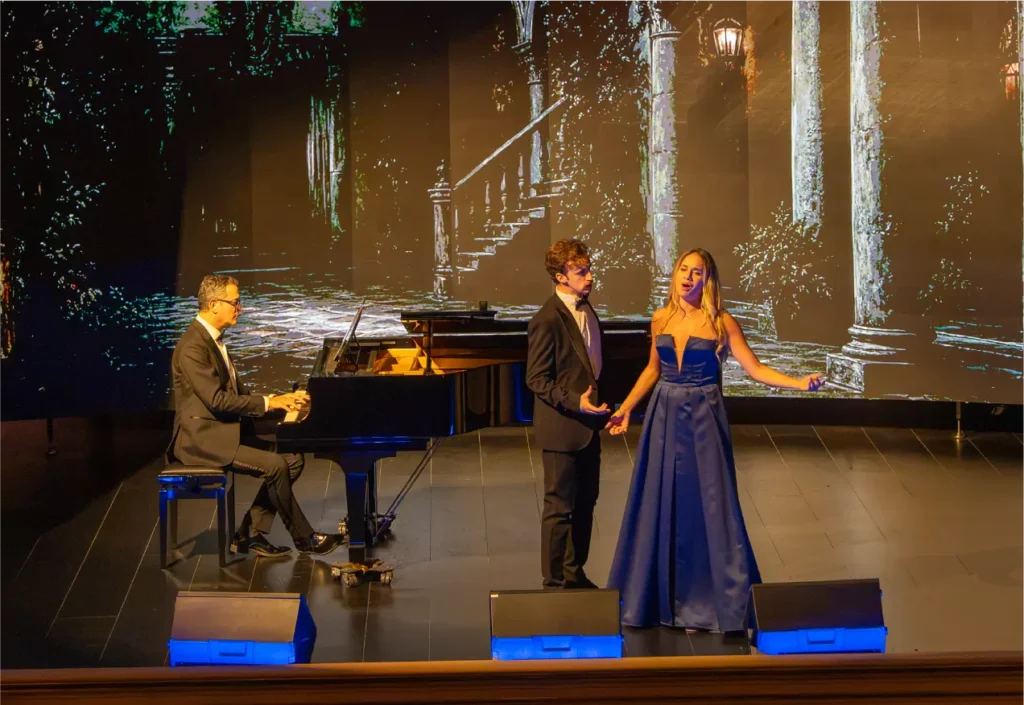 Due cantanti lirici e un pianista si esibiscono sul palco del Teatro Nazionale di Firenze durante lo spettacolo Voci d'Italia