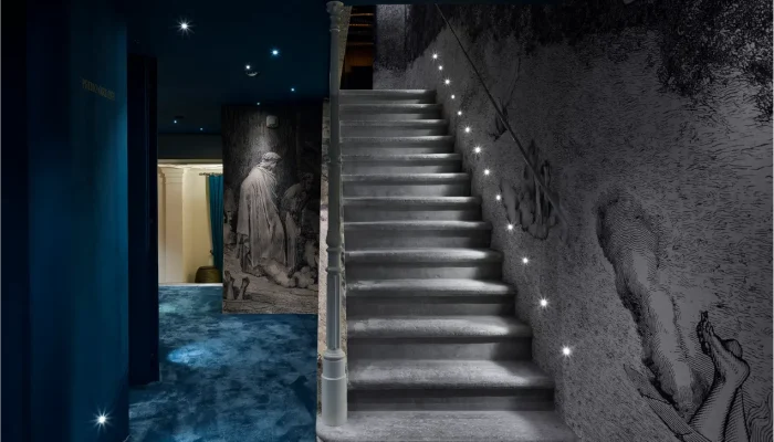 Historic stone staircase with step lighting and Dante-inspired wall engravings